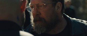 Movie still from “Skin” (2018), directed by Guy Nattiv – A man with a long beard and glasses looking to his left; Close Up shot, Over the shoulder angle