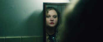 Movie still from “Skin” (2018), directed by Guy Nattiv – A woman looking into a mirror in front of a wall; Close Up shot, Over the shoulder angle