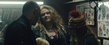 Movie still from “Skin” (2018), directed by Guy Nattiv – A woman in a leather jacket is standing next to two other people; Medium shot, Over the shoulder angle