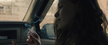 Movie still from “Skin” (2018), directed by Guy Nattiv – A woman sitting in a car with a cigarette in her mouth; Close Up shot, Over the shoulder angle
