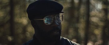 Movie still from “Skin” (2018), directed by Guy Nattiv – A person wearing glasses and a hat; Close Up shot, Low angle