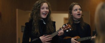 Movie still from “Skin” (2018), directed by Guy Nattiv – Two young girls are playing the ukulele together; Close Up shot, Over the shoulder angle