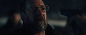 Movie still from “Skin” (2018), directed by Guy Nattiv – A man with a beard wearing glasses looking at the camera; Close Up shot, Over the shoulder angle