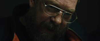 Movie still from “Skin” (2018), directed by Guy Nattiv – A person with a beard wearing glasses; Extreme Close Up shot, Over the shoulder angle