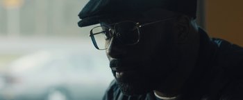Movie still from “Skin” (2018), directed by Guy Nattiv – A person wearing glasses and a hat; Close Up shot, Over the shoulder angle