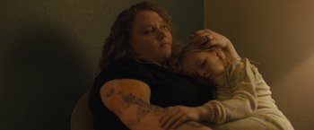 Movie still from “Skin” (2018), directed by Guy Nattiv – A woman and a child are sitting on a couch; Close Up shot, High angle