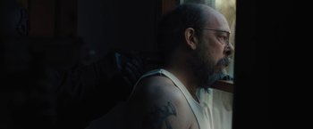 Movie still from “Skin” (2018), directed by Guy Nattiv – A man with a beard is getting a tattoo on his arm; Close Up shot, Over the shoulder angle