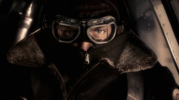 Movie still from “Sky Captain and the World of Tomorrow” (2004), directed by Kerry Conran – A man wearing a leather jacket and goggles looking at the camera; Close Up shot, High angle