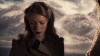 Movie still from “Sky Captain and the World of Tomorrow” (2004), directed by Kerry Conran – A woman in a trench coat is standing in front of a cloudy sky; Close Up shot, Low angle