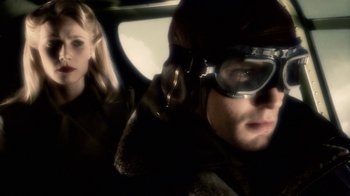 Movie still from “Sky Captain and the World of Tomorrow” (2004), directed by Kerry Conran – A man and a woman in a car with goggles on; Close Up shot, Over the shoulder angle