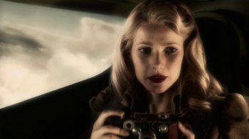 Movie still from “Sky Captain and the World of Tomorrow” (2004), directed by Kerry Conran – A woman holding a camera while sitting in a car; Close Up shot, Low angle
