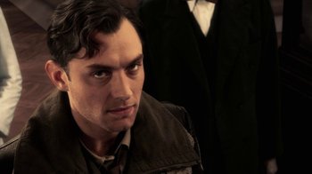 Movie still from “Sky Captain and the World of Tomorrow” (2004), directed by Kerry Conran – A person wearing a suit and tie; Close Up shot, Over the shoulder angle