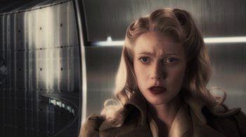 Movie still from “Sky Captain and the World of Tomorrow” (2004), directed by Kerry Conran – A woman in a trench coat with blonde hair; Close Up shot, Low angle