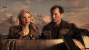 Movie still from “Sky Captain and the World of Tomorrow” (2004), directed by Kerry Conran – A man and a woman standing next to each other in front of an airplane; Medium shot, Low angle