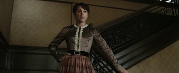 Movie still from “Godless” (2017), directed by Scott Frank – A woman standing on the stairs wearing a dress; Medium shot, Low angle