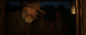 Movie still from “Godless” (2017), directed by Scott Frank – A man with a long beard wearing a cowboy hat; Close Up shot, Over the shoulder angle