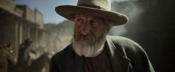 Movie still from “Godless” (2017), directed by Scott Frank – An old man with a white beard wearing a hat; Close Up shot, Over the shoulder angle