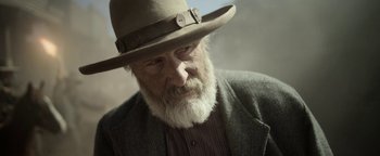Movie still from “Godless” (2017), directed by Scott Frank – An old man with a beard wearing a hat; Close Up shot, Low angle