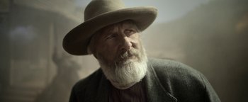 Movie still from “Godless” (2017), directed by Scott Frank – An old man with a long white beard wearing a hat; Close Up shot, Low angle