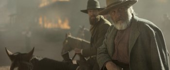 Movie still from “Godless” (2017), directed by Scott Frank – A couple of men riding on the back of a horse; Medium shot, Over the shoulder angle