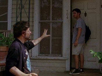 Movie still from “Slacker” (1990), directed by Richard Linklater – Two men standing in front of a door; Medium shot, Over the shoulder angle