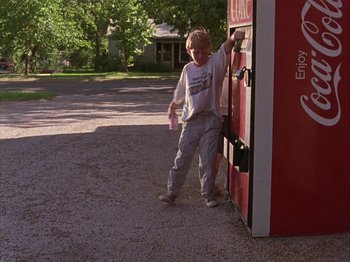 Movie still from “Slacker” (1990), directed by Richard Linklater – A young boy standing in front of a vending machine; Wide shot, Low angle