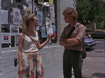 Movie still from “Slacker” (1990), directed by Richard Linklater – A man and a woman standing next to each other on the sidewalk; Medium shot, Over the shoulder angle