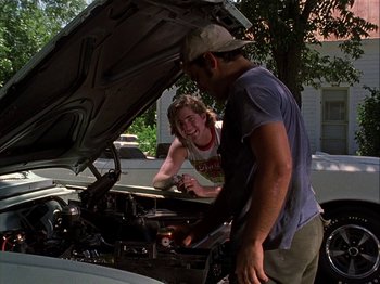 Movie still from “Slacker” (1990), directed by Richard Linklater – A man and a woman looking under the hood of a car; Medium shot, Over the shoulder angle