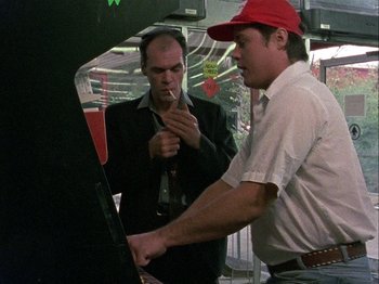 Movie still from “Slacker” (1990), directed by Richard Linklater – Two men standing next to each other in front of an oven; Medium shot, Over the shoulder angle