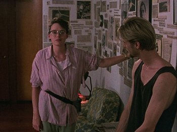 Movie still from “Slacker” (1990), directed by Richard Linklater – A man and a woman are standing in front of a wall; Medium shot, Over the shoulder angle
