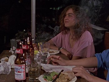 Movie still from “Slacker” (1990), directed by Richard Linklater – A group of people sitting at a dinner table; Medium shot, Over the shoulder angle