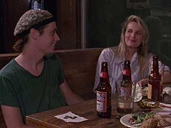 Movie still from “Slacker” (1990), directed by Richard Linklater – A man and a woman sitting at a table with beer in front of them; Medium shot, Over the shoulder angle