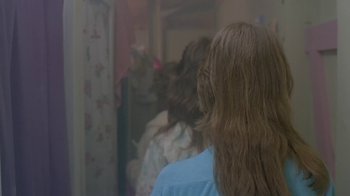 A woman standing in front of a bathroom mirror