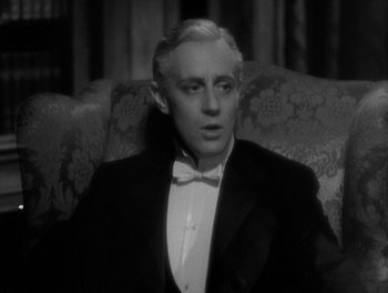Movie still from “Smilin' Through” (1932), directed by Sidney Franklin – A man in a tuxedo sitting on a couch; Close Up shot, High angle