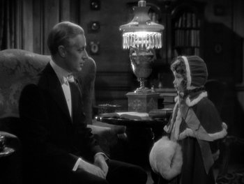Movie still from “Smilin' Through” (1932), directed by Sidney Franklin – A man sitting next to a little girl in front of a lamp; Medium shot, High angle