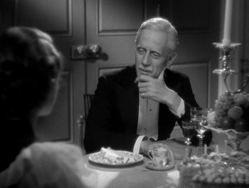 Movie still from “Smilin' Through” (1932), directed by Sidney Franklin – An older man sitting at a table with a plate of food; Close Up shot, Over the shoulder angle