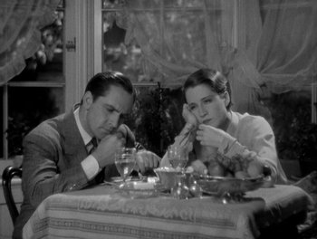 Movie still from “Smilin' Through” (1932), directed by Sidney Franklin – A man and a woman sitting at a dinner table; Medium shot, High angle