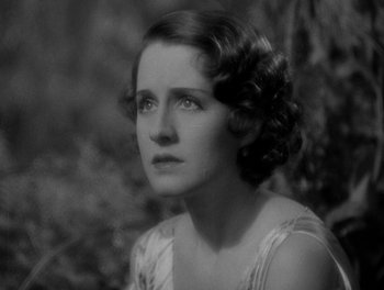 Movie still from “Smilin' Through” (1932), directed by Sidney Franklin – An old photo of a woman in a white dress; Close Up shot, High angle
