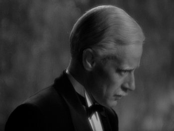 Movie still from “Smilin' Through” (1932), directed by Sidney Franklin – A black and white photo of a man in a tuxedo; Close Up shot, Over the shoulder angle
