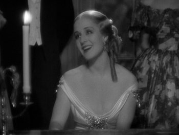 Movie still from “Smilin' Through” (1932), directed by Sidney Franklin – A black and white photo of a woman in a white dress; Medium shot, High angle