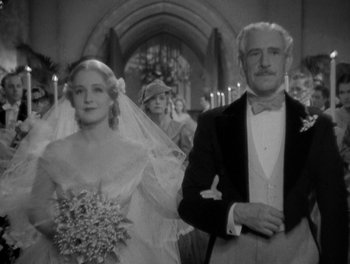 Movie still from “Smilin' Through” (1932), directed by Sidney Franklin – An older man and a young woman walking down the aisle of a church; Medium shot, Low angle