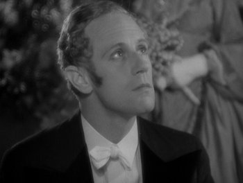 Movie still from “Smilin' Through” (1932), directed by Sidney Franklin – A man in a suit and bow tie looking up at the sky; Close Up shot, Low angle