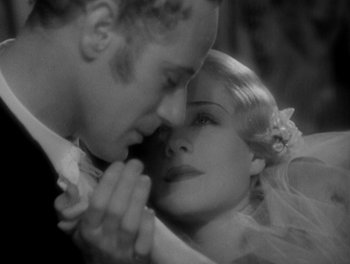 Movie still from “Smilin' Through” (1932), directed by Sidney Franklin – A black and white photo of a man and a woman kissing; Close Up shot, High angle