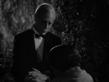 Movie still from “Smilin' Through” (1932), directed by Sidney Franklin – A black and white photo of a man and a woman; Medium shot, Over the shoulder angle