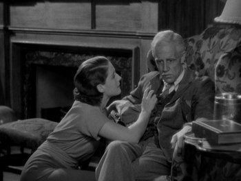 Movie still from “Smilin' Through” (1932), directed by Sidney Franklin – An old photo of a man and a woman sitting on a couch; Medium shot, High angle