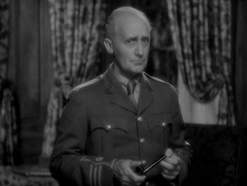 Movie still from “Smilin' Through” (1932), directed by Sidney Franklin – An older man in a military uniform holding a cell phone; Close Up shot, High angle