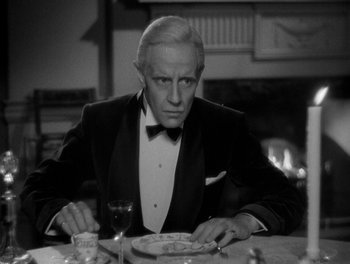 Movie still from “Smilin' Through” (1932), directed by Sidney Franklin – An older man sitting at a table with a plate of food in front of him; Close Up shot, High angle