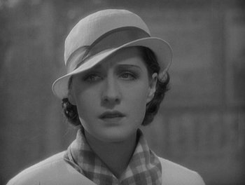 Movie still from “Smilin' Through” (1932), directed by Sidney Franklin – A black and white photo of a woman wearing a hat; Close Up shot, High angle