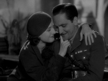 Movie still from “Smilin' Through” (1932), directed by Sidney Franklin – A man and a woman embracing each other in a black and white photo; Medium shot, High angle