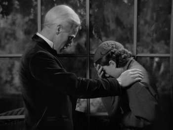Movie still from “Smilin' Through” (1932), directed by Sidney Franklin – An older man and a younger man are touching each other; Medium shot, High angle